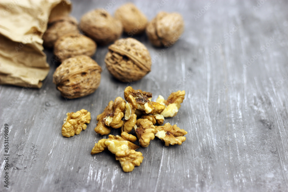 Walnut kernels and whole nuts on an old gray table. Seletive focus Walnut kernels and whole nuts on an old gray table. Seletive focus