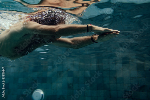 sporty man swimming in pool