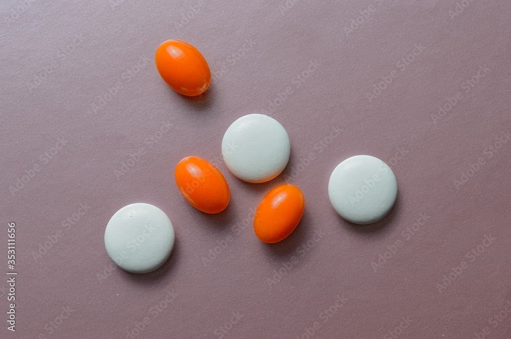 multi-colored pills and vitamins in capsules on a pink background. top view multi-colored pills and vitamins in capsules on a pink background. top view