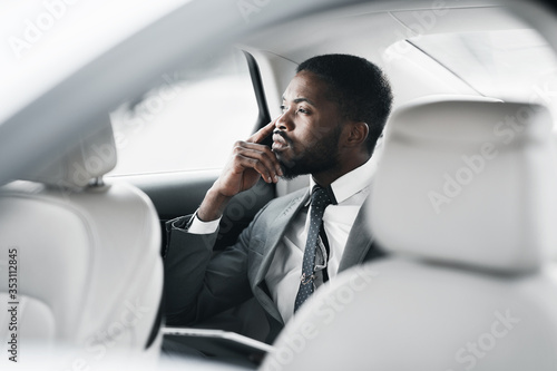 Thoughtful Black Businessman Sitting In Car Looking Out Of Window