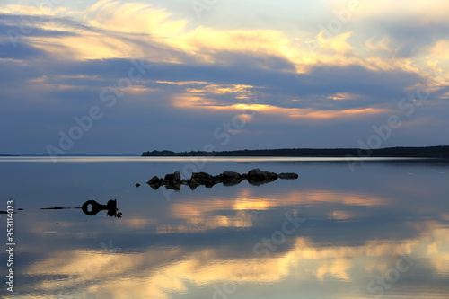 stones in river on sunset background