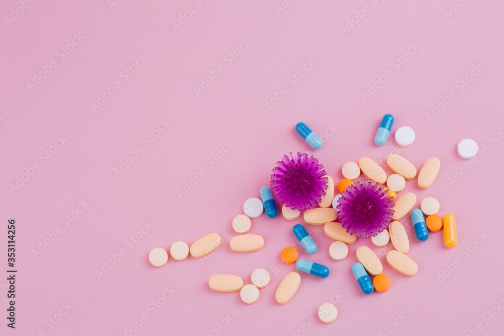 Violet virus and a diverse pill on a pink background, the risk of a pandemic. Violet virus and a diverse pill on a pink background, the risk of a pandemic.