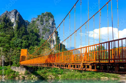 Landcape of muontain in vangvien Laos with long orange bridge and The beautiful mountains rang as a backdrop photo