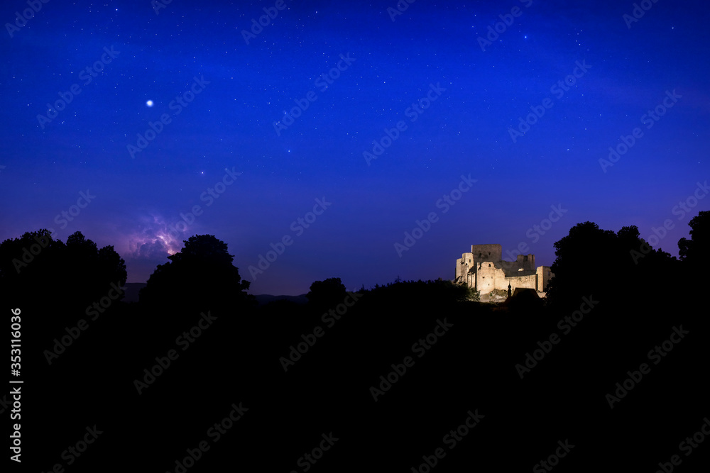 The largest castle ruin in Bohemia - Rabí (Rabi) in the night scenery with Jupiter and a storm in the distance in the sky. 