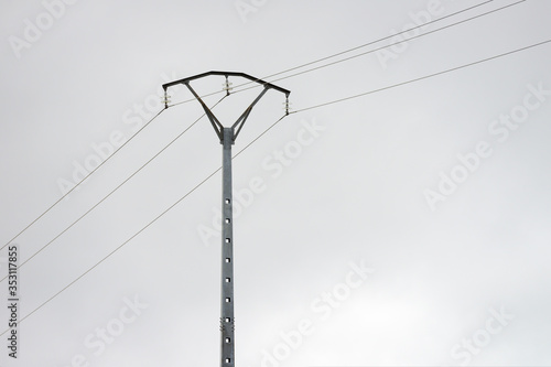 pole power lines against a gray cloudy sky