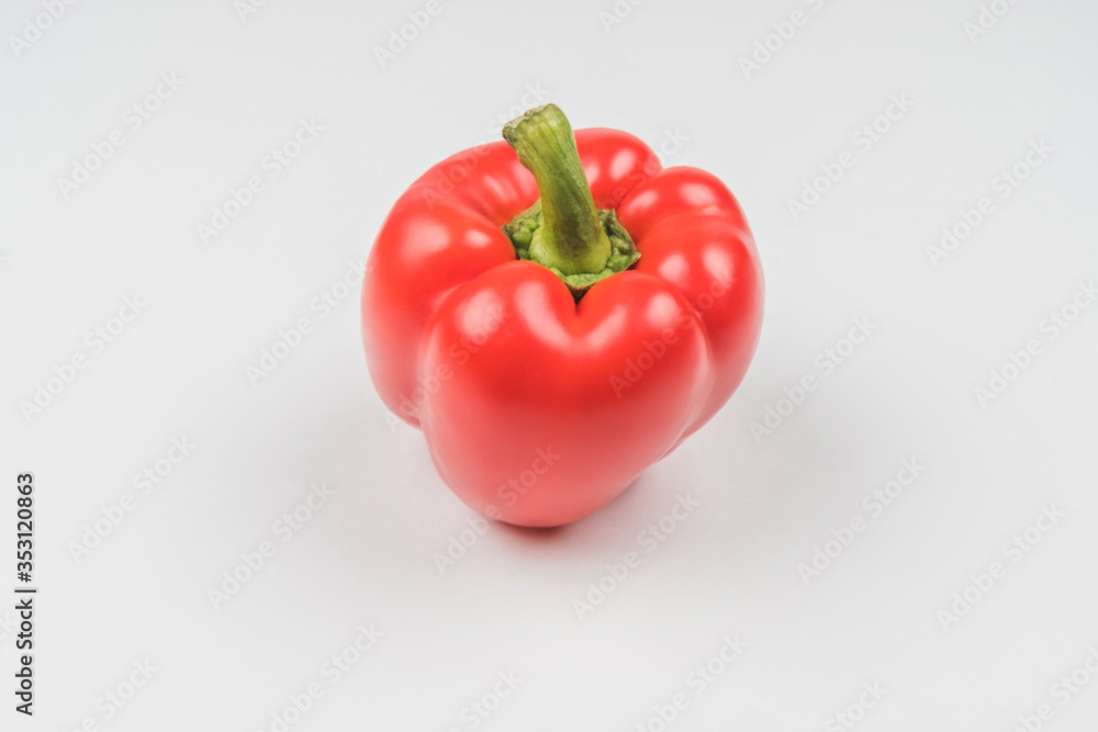 Ripe red pepper on a light background