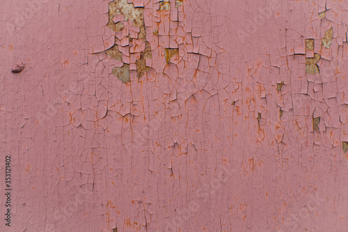 Peeling red paint on rusty metal wall. Close up pattern of rustic grunge material