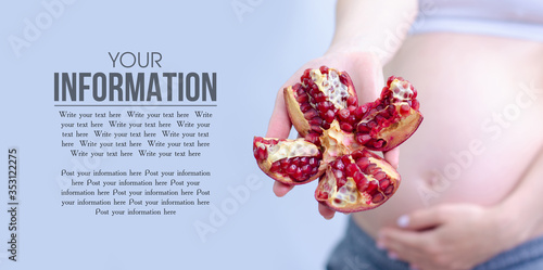 Pregnant woman holding fresh pomegranate on gray background, space for text