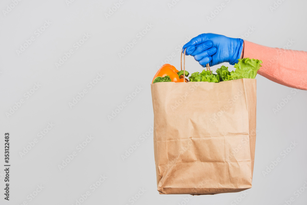 Paper bag with products from the delivery man's hand on a white background. Paper bag with products from the delivery man's hand on a white background.