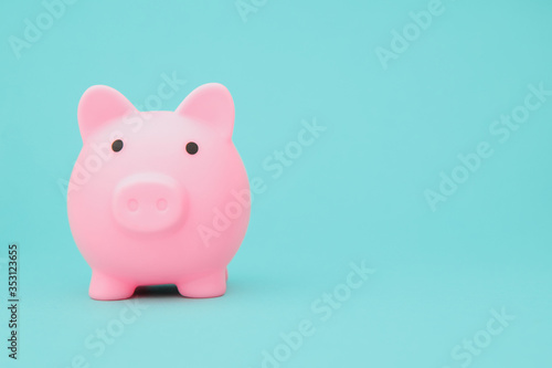 Savings concept. Moneybox in shape of pig on blue background space for text.