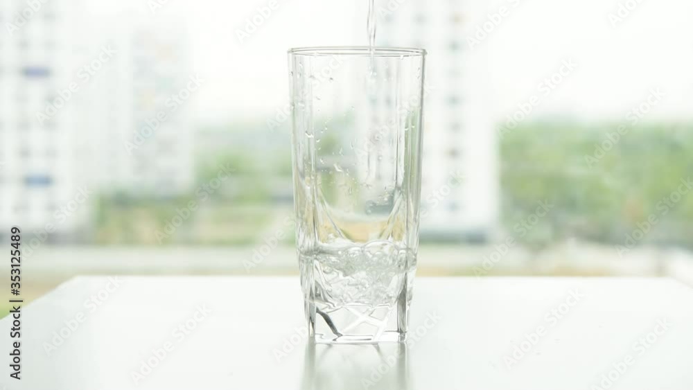 water is poured into a clear glass of water water is poured into a clear glass of water