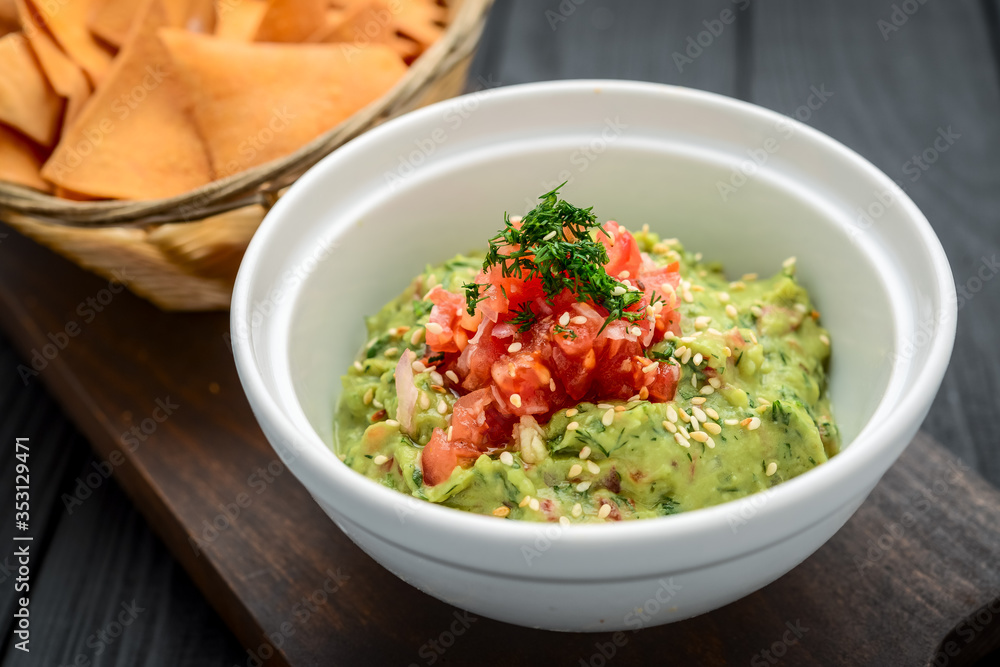A delicious authentic mexican guacamole dip with avocado, lime, and tomato.