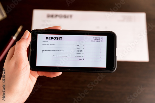 Fotografie Man Taking Photo Of Cheque To Make Remote Deposit In bank