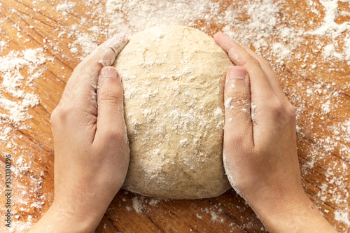 Woman's hands on raw dough