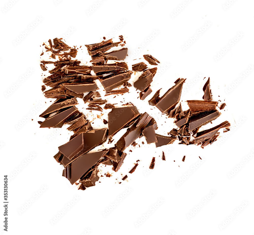 Fototapeta premium Chocolate broken pieces and shavings isolated on white background. Chunks of dark chocolate falling, top view