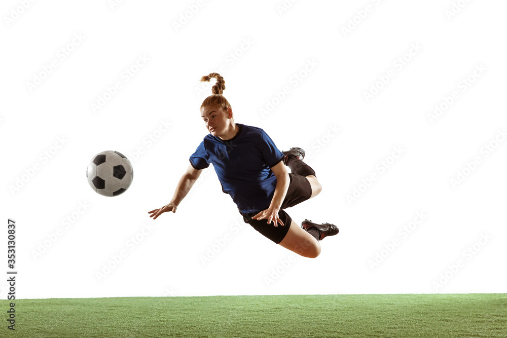 Young female soccer or football player with long hair kicking ball for the goal in flight, jumping high on white studio background. Concept of healthy lifestyle, professional sport, motion, movement. Young female soccer or football player with long hair kicking ball for the goal in flight, jumping high on white studio background. Concept of healthy lifestyle, professional sport, motion, movement.