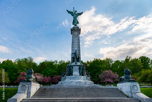 Monument to Sir George-Étienne Cartier in Mount Royal Park, front view with clouds and blue sky, 