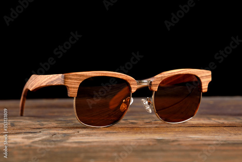 Bright wooden sunglasses on wooden surface