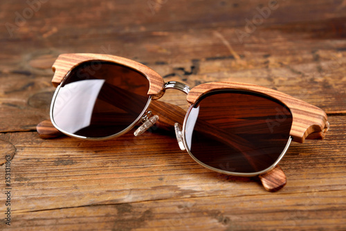 Bright wooden sunglasses on wooden surface