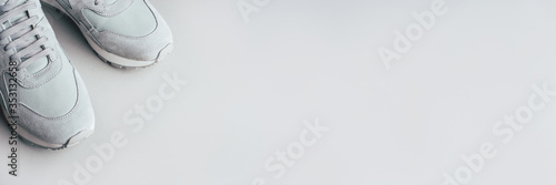 Gray sneakers on a gray background. A trending monochrome image for your design. Copy space for text.