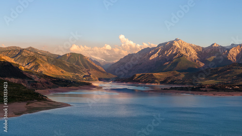 Beautiful mountain lake. Amazing mountain landscape with lake and sunset. Uzbekistan, Charvak Lake, 2020