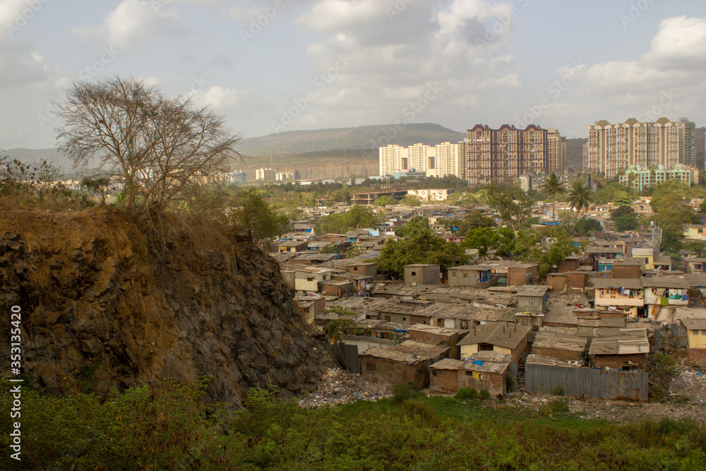 view of the city with high rises and slums living side by side, disparity in wealthy and poor