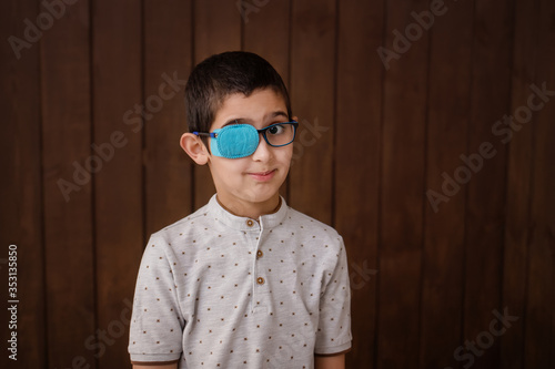 Portrait of boy in glasses with patch. Eye patch for glasses t treat lazy eye, amblyopia, strabismus. 