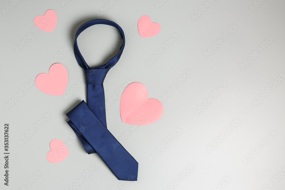 blue tie and pink hearts on a gray background. happy father's day holiday concept. top view, flat lay, copy space. blue tie and pink hearts on a gray background. happy father's day holiday concept. top view, flat lay, copy space.