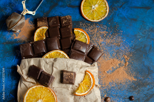 pieces of dark chocolate in a paper bag with dried oranges
