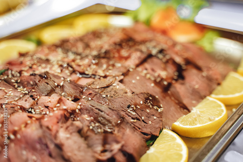 Sliced seasoned roast beef on a buffet table