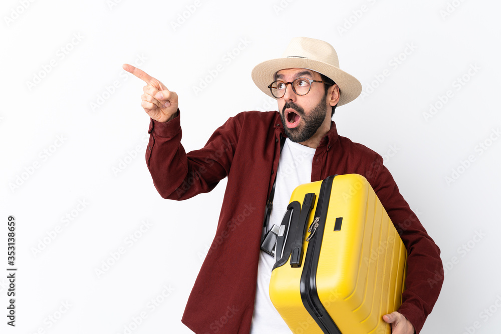 Traveler man man with beard holding a suitcase over isolated white background pointing away Traveler man man with beard holding a suitcase over isolated white background pointing away