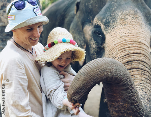 Photography Family feeding elephant in a savannah environment at the Zoo