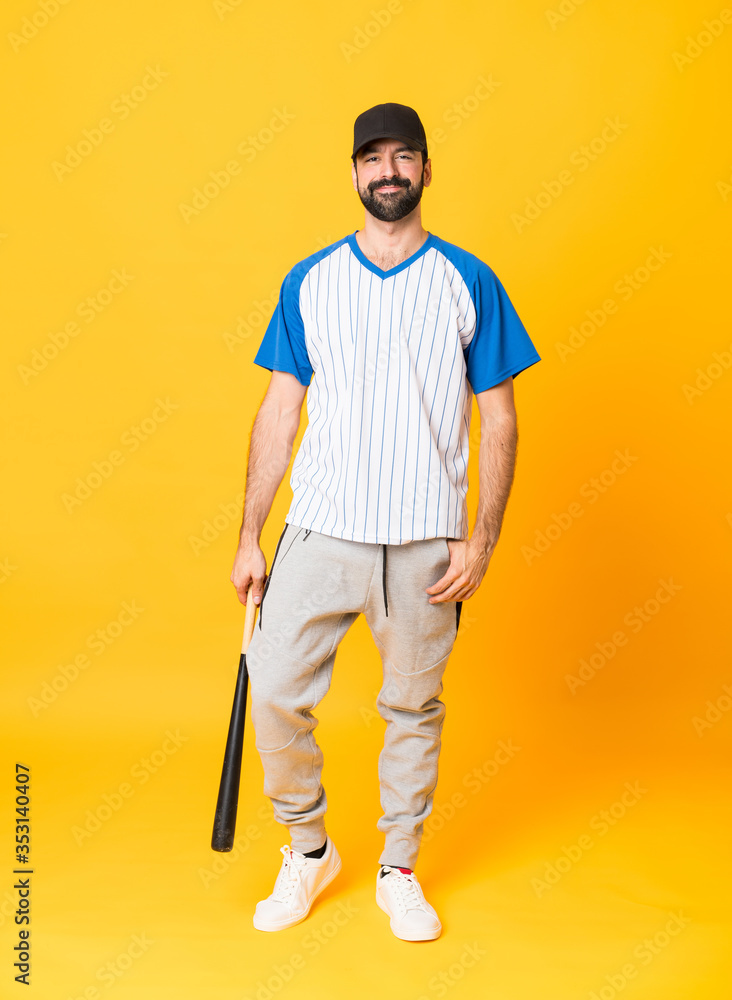 Full-length shot of a man playing baseball over isolated yellow background Full-length shot of a man playing baseball over isolated yellow background