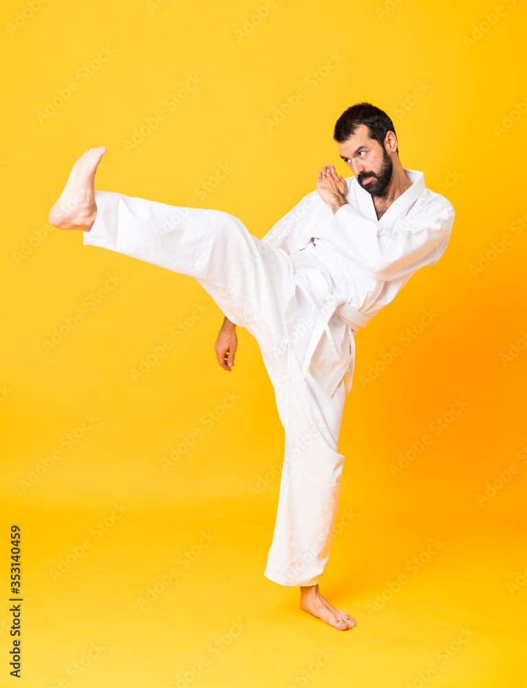 Full-length shot of mandoing karate over isolated yellow background