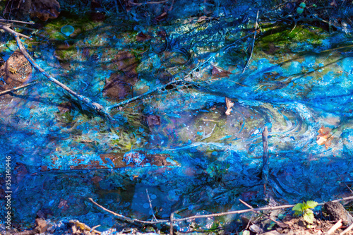 Fototapeta Naklejka Na Ścianę i Meble -  a creek polluted with blue paint. Environmental Protection.