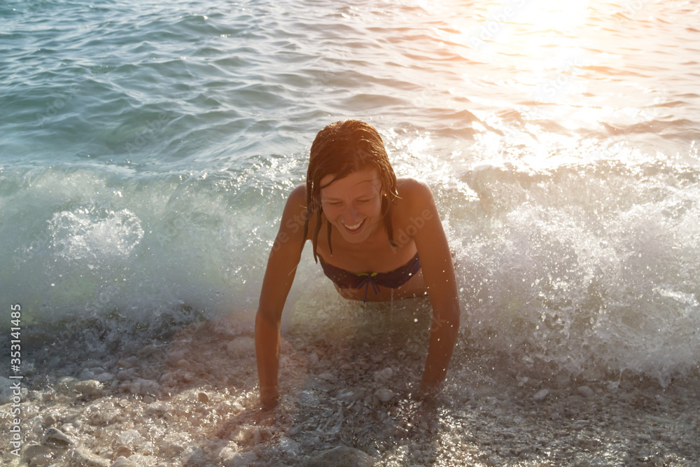 Young woman enjoying summertime in the ocean / sea water.