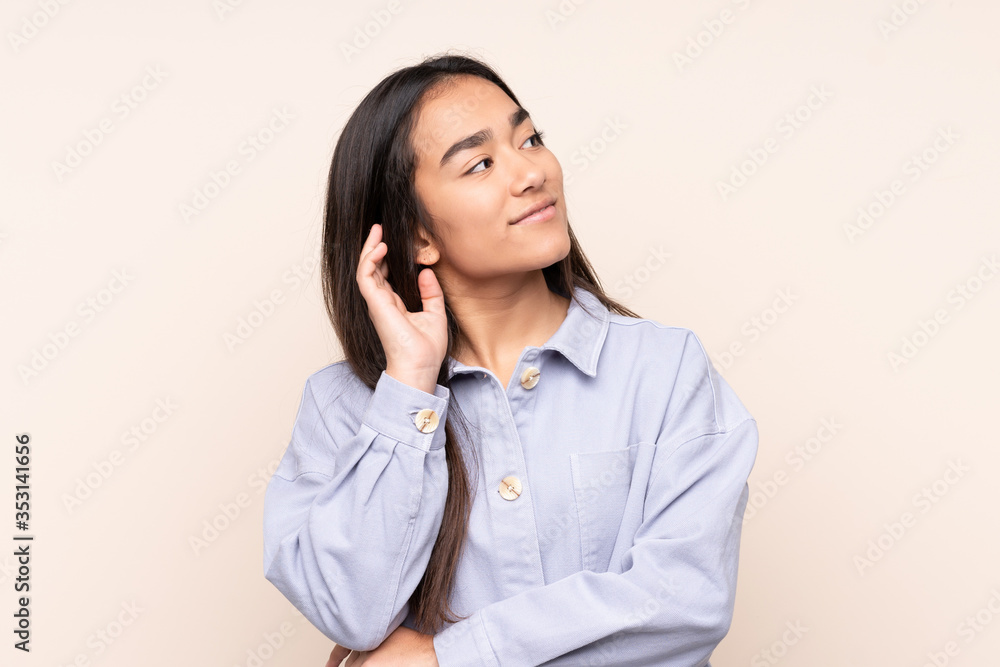 Young Indian woman isolated on beige background thinking an idea Young Indian woman isolated on beige background thinking an idea