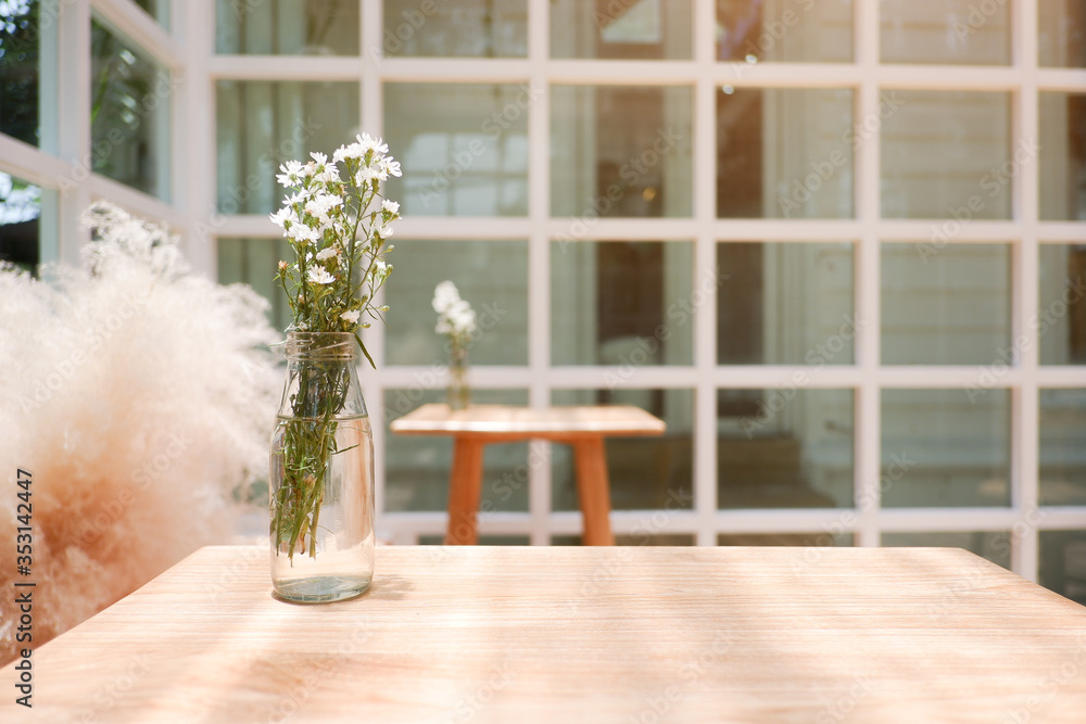 Fototapeta premium Natural ordinary view and objects for background. Flower in the jar set on the wood table.