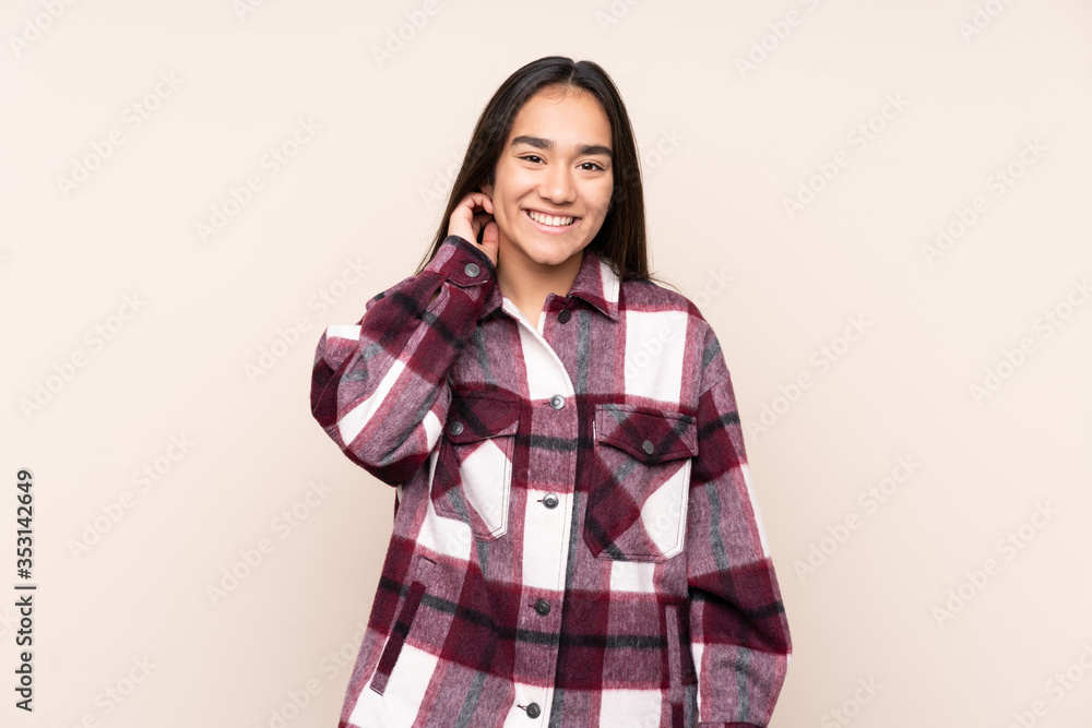 Young Indian woman isolated on beige background laughing Young Indian woman isolated on beige background laughing