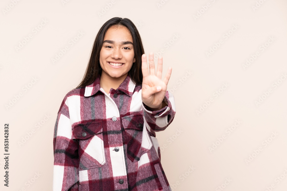 Young Indian woman isolated on beige background happy and counting four with fingers Young Indian woman isolated on beige background happy and counting four with fingers