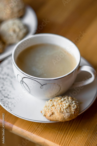 Cup of black coffee and plate with peanut butter cookies on a table.