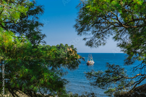 A tourist ship stands near the coast in the Mediterranean sea Turkey.The most popular tourist attraction is a boat tour along the Mediterranean coast.