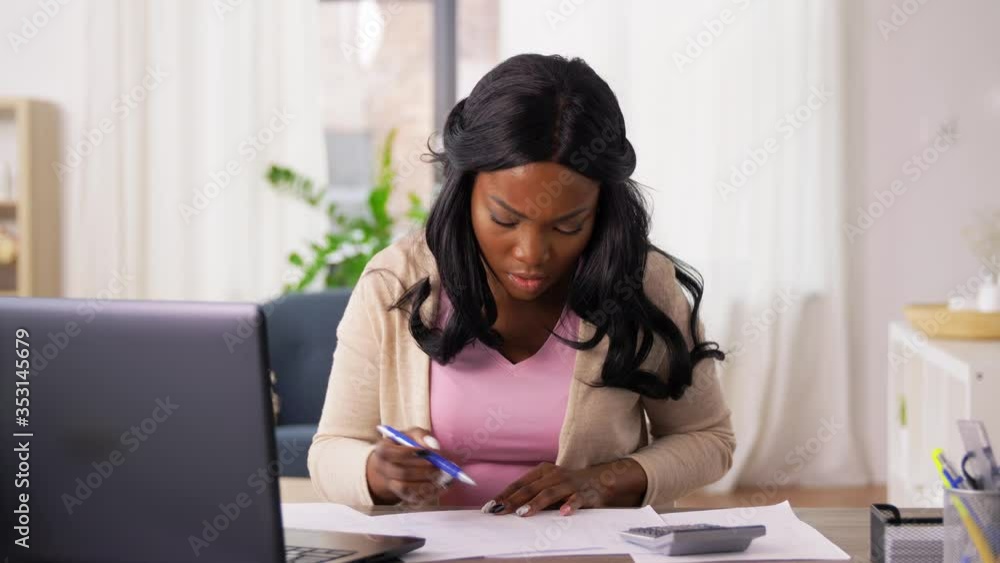 remote job, technology and people concept - young african american woman with calculator and papers working at home office and celebrating success remote job, technology and people concept - young african american woman with calculator and papers working at home office and celebrating success