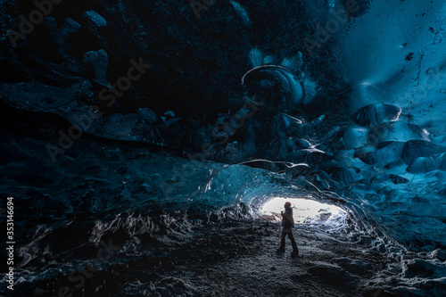 A man with ice axe in the fantastic Icelandic ice cave. South Iceland.