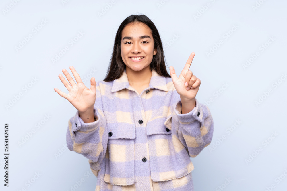 Young Indian woman isolated on blue background counting seven with fingers Young Indian woman isolated on blue background counting seven with fingers