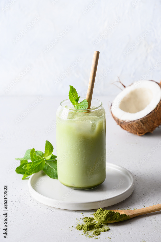 Iced Green matcha tea in glass with coconut milk garnish mint on white background. Close up.Vertical format. Iced Green matcha tea in glass with coconut milk garnish mint on white background. Close up.Vertical format.