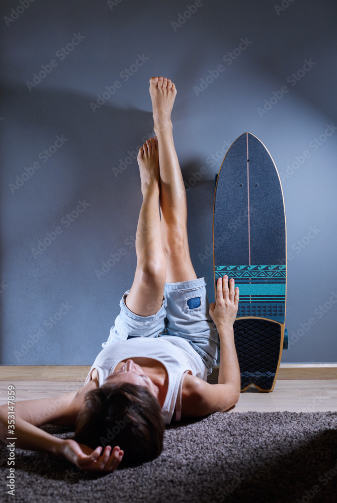 Girl lying on the floor with legs up the wall is imitating sitting near
