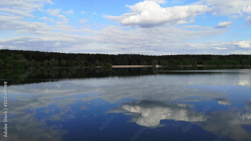 Clouds on a blue sky with reflection on the surface of the water in the lake. Clouds on a blue sky with reflection on the surface of the water in the lake.
