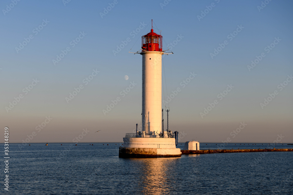 The Odessa Lighthouse at sunset with the moon in the background.