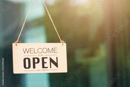 WELCOME WE ARE OPEN PLEASE COME IN notice sign wood board label hanging through glass door photo